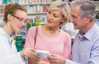 Elderly couple looking at medicine with pharmacist