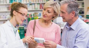 A drugstore employee assists customers.